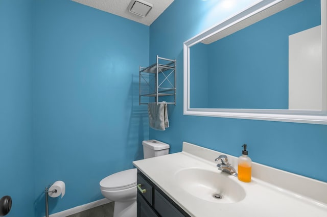 bathroom with a textured ceiling, toilet, and vanity