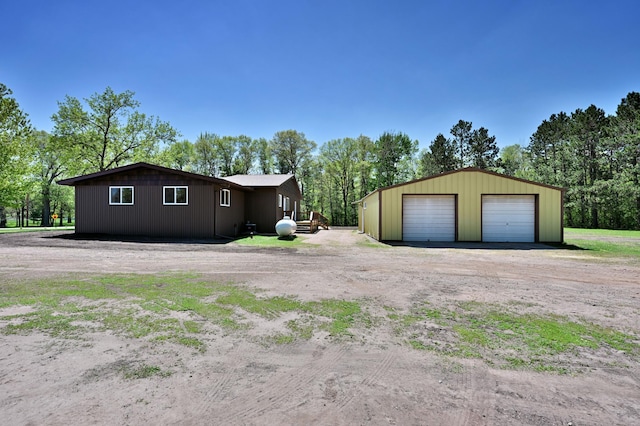 28257 French Rd, Danbury, WI 54830 - view of side of home with a garage, an outdoor structure, driveway, and view of scattered trees