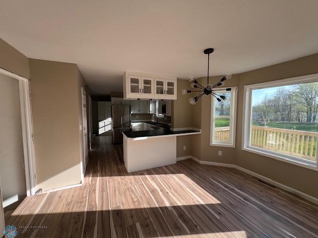 24129 County Road 144, Detroit Twp, MN 56501 - kitchen featuring a chandelier, dark wood finished floors, a peninsula, and dark countertops