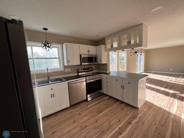 24129 County Road 144, Detroit Twp, MN 56501 - kitchen featuring stainless steel appliances, a sink, a textured ceiling, light wood-style floors, and white cabinets