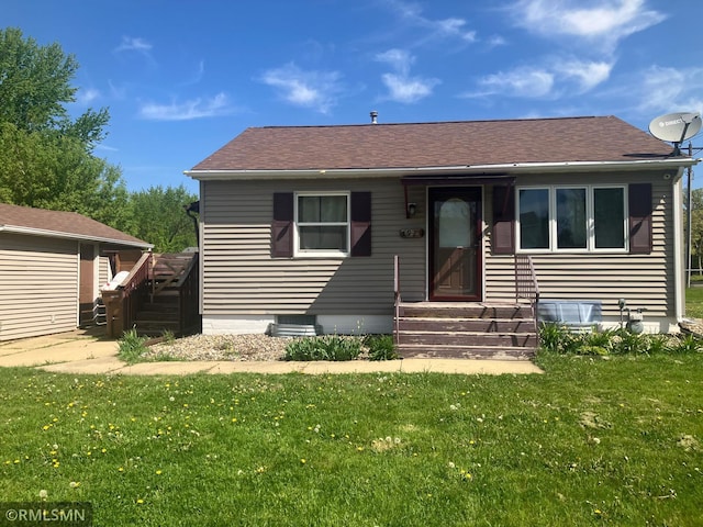 view of front of home with a front lawn and roof with shingles