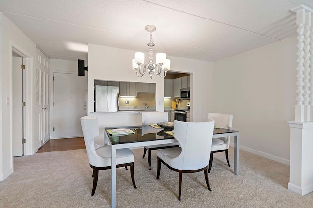 dining space with light colored carpet, a chandelier, and baseboards