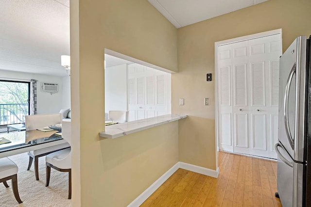 hallway featuring baseboards and light wood-type flooring
