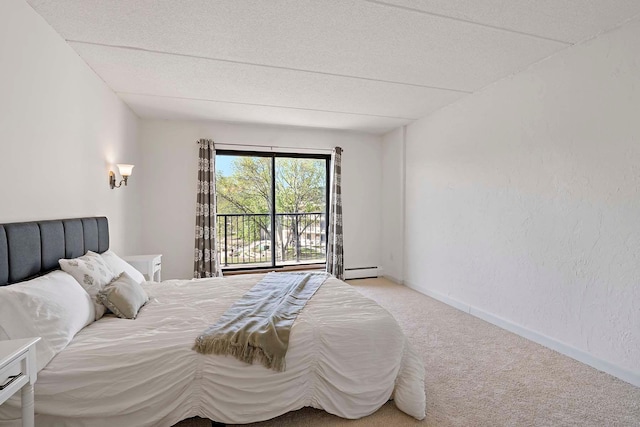 bedroom with carpet flooring, a baseboard radiator, a textured ceiling, and a textured wall
