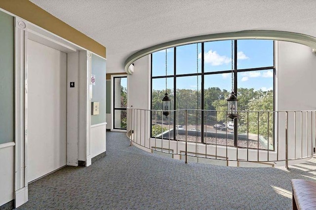 interior space featuring carpet flooring, a textured ceiling, and elevator