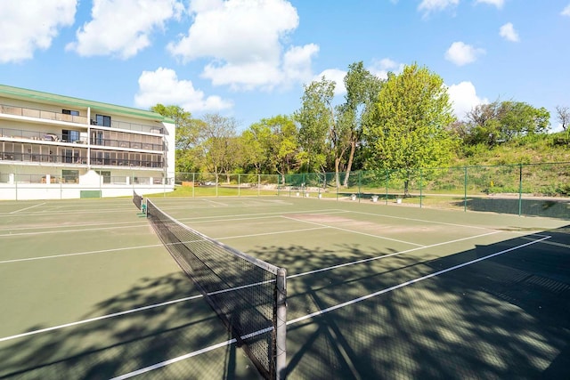 view of tennis court featuring fence and community basketball court