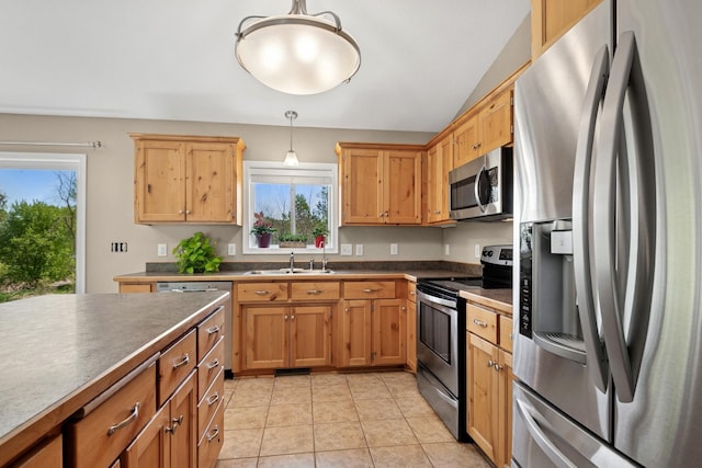 23141 Hilo Ave N, Forest Lake, MN 55025 - kitchen featuring stainless steel appliances, a sink, dark countertops, decorative light fixtures, and light tile patterned floors