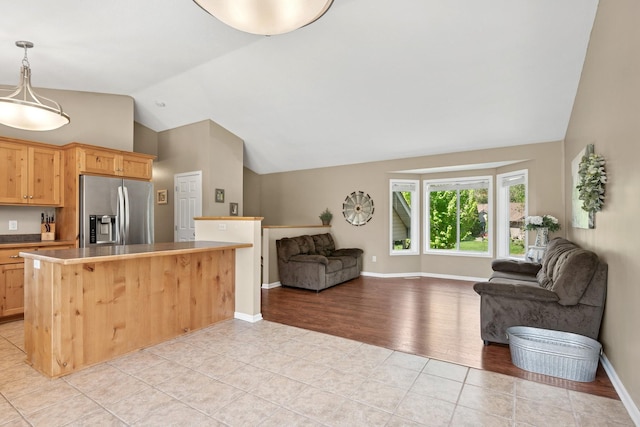 23141 Hilo Ave N, Forest Lake, MN 55025 - kitchen with stainless steel fridge, open floor plan, light tile patterned floors, high vaulted ceiling, and baseboards