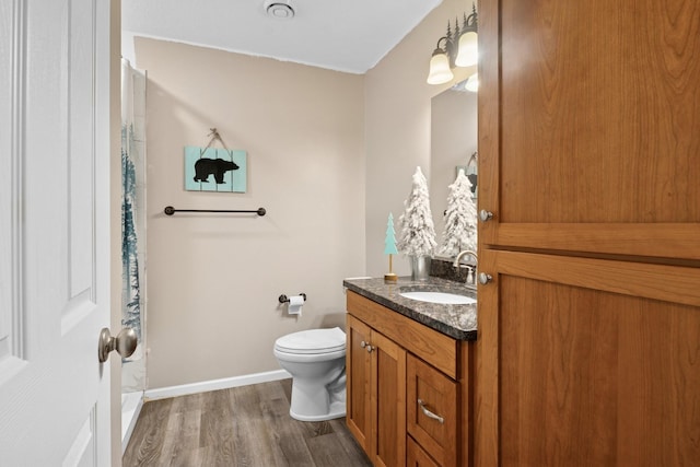 23141 Hilo Ave N, Forest Lake, MN 55025 - bathroom with wood finished floors, toilet, vanity, baseboards, and curtained shower