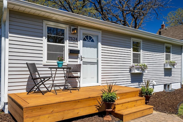 view of exterior entry featuring a wooden deck