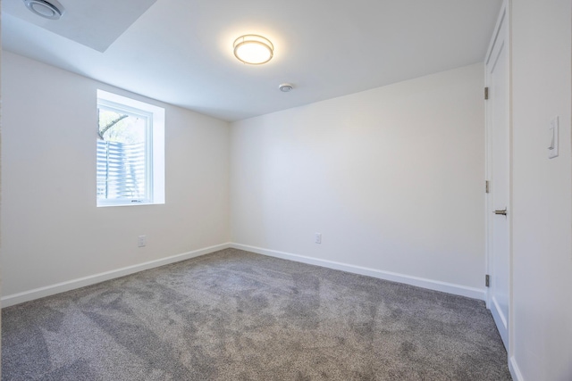 spare room featuring carpet floors and baseboards