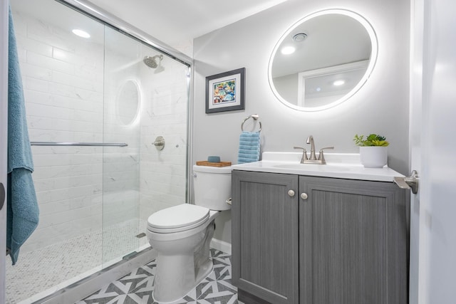full bath with toilet, vanity, and a shower stall