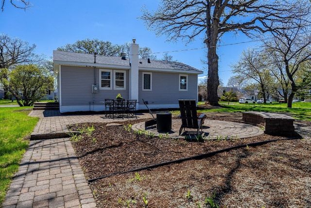 rear view of house with a patio and a chimney