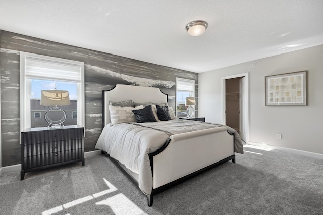 carpeted bedroom featuring baseboards and a spacious closet
