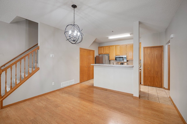 8497 Cortland Rd, Eden Prairie, MN 55344 - kitchen with appliances with stainless steel finishes, light wood finished floors, pendant lighting, baseboards, and light countertops