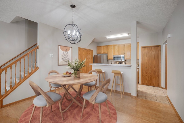 8497 Cortland Rd, Eden Prairie, MN 55344 - dining space featuring light wood-style floors, stairway, baseboards, and a textured ceiling