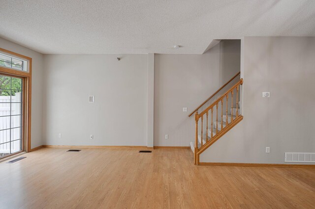 8497 Cortland Rd, Eden Prairie, MN 55344 - unfurnished living room with wood finished floors, a textured ceiling, stairway, and baseboards
