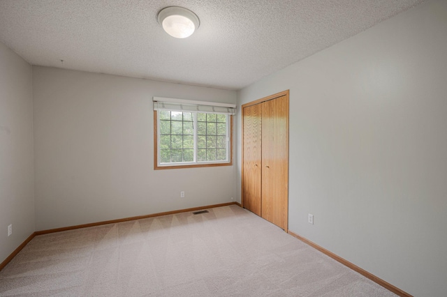 8497 Cortland Rd, Eden Prairie, MN 55344 - unfurnished bedroom with a textured ceiling, carpet, a closet, and baseboards
