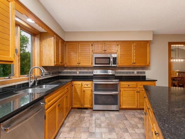 71156 Csah 18, Collinwood Twp, MN 55325 - kitchen with appliances with stainless steel finishes, a sink, decorative backsplash, stone finish flooring, and dark stone counters