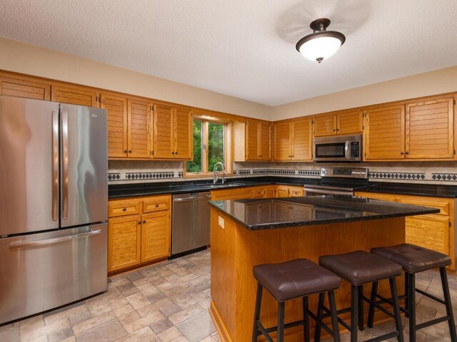71156 Csah 18, Collinwood Twp, MN 55325 - kitchen featuring stainless steel appliances, a sink, tasteful backsplash, and a kitchen breakfast bar