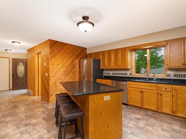 71156 Csah 18, Collinwood Twp, MN 55325 - kitchen with appliances with stainless steel finishes, a sink, backsplash, a center island, and stone finish flooring