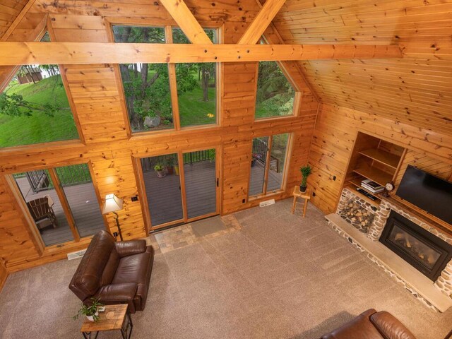 71156 Csah 18, Collinwood Twp, MN 55325 - unfurnished living room with wood walls, carpet flooring, high vaulted ceiling, beamed ceiling, and a stone fireplace