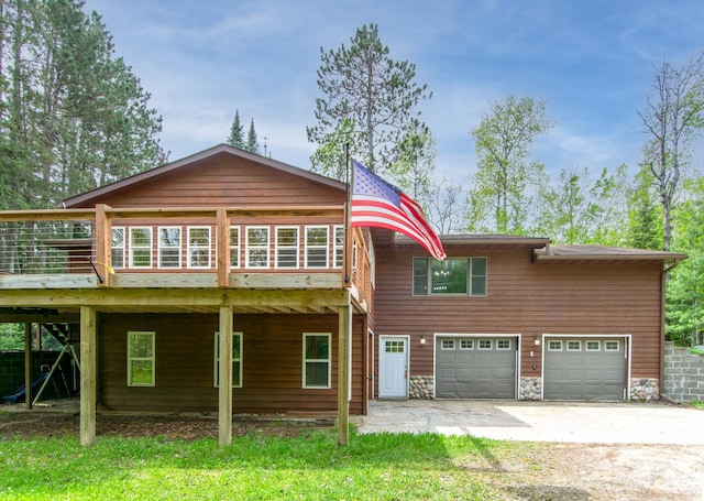 51850 Scenic Hwy Unit 7, Bigfork, MN 56628 - rear view of property with an attached garage, driveway, a deck, and stone siding