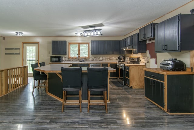 51850 Scenic Hwy Unit 7, Bigfork, MN 56628 - kitchen featuring stainless steel gas range oven, light countertops, black microwave, a breakfast bar area, and a sink