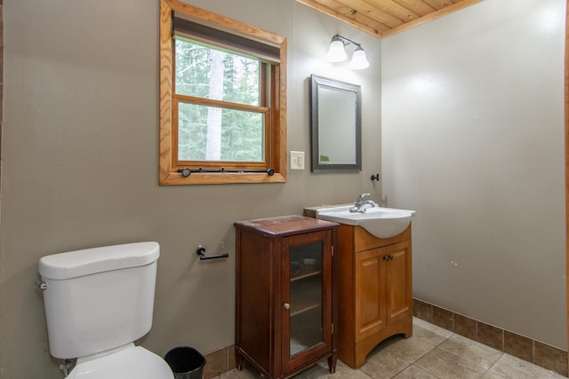51850 Scenic Hwy Unit 7, Bigfork, MN 56628 - bathroom featuring wooden ceiling, toilet, baseboards, vanity, and tile patterned flooring