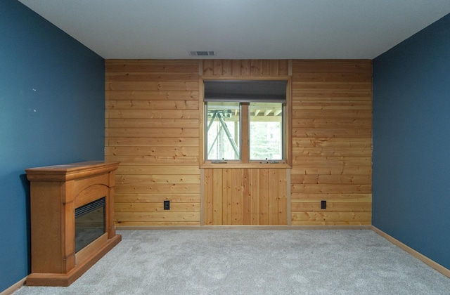 51850 Scenic Hwy Unit 7, Bigfork, MN 56628 - unfurnished living room with wooden walls, baseboards, carpet, and a glass covered fireplace