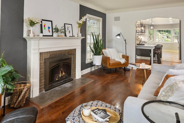 1112 Vincent Ave S, Minneapolis, MN 55405 - living area with wood finished floors, arched walkways, a brick fireplace, and baseboards