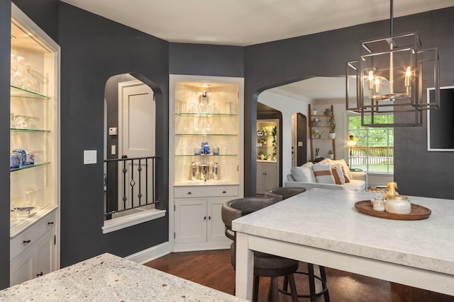 1112 Vincent Ave S, Minneapolis, MN 55405 - kitchen with arched walkways, light countertops, dark wood-type flooring, decorative light fixtures, and open floor plan