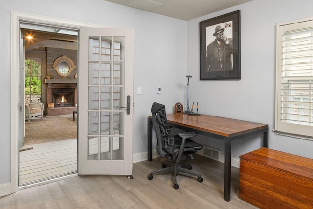 1112 Vincent Ave S, Minneapolis, MN 55405 - home office with wood finished floors, plenty of natural light, a large fireplace, and baseboards