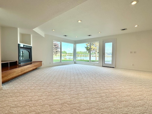1976 Bay St, Worthington, MN 56187 - unfurnished living room featuring carpet, baseboards, recessed lighting, and a water view