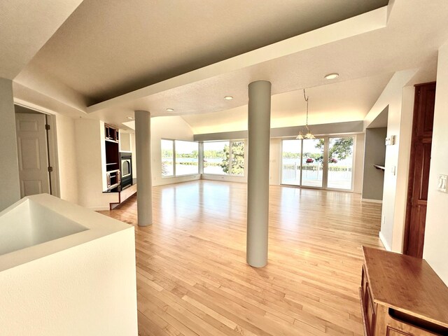 1976 Bay St, Worthington, MN 56187 - unfurnished living room featuring a raised ceiling, healthy amount of natural light, a chandelier, and recessed lighting