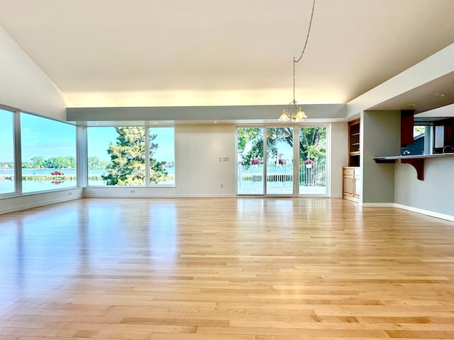 1976 Bay St, Worthington, MN 56187 - unfurnished living room featuring light wood-style flooring, a chandelier, and baseboards