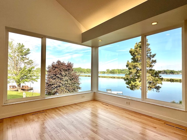1976 Bay St, Worthington, MN 56187 - unfurnished sunroom with a water view, wood-type flooring, healthy amount of natural light, and vaulted ceiling