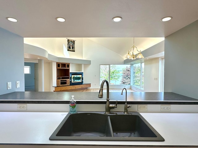 1976 Bay St, Worthington, MN 56187 - kitchen featuring a sink, recessed lighting, dark countertops, a chandelier, and vaulted ceiling