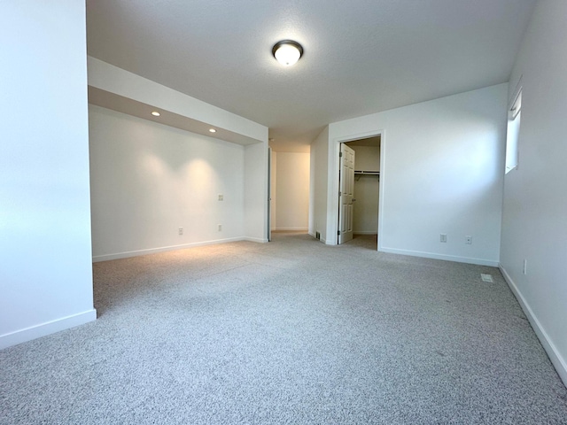 1976 Bay St, Worthington, MN 56187 - unfurnished bedroom featuring light colored carpet, baseboards, recessed lighting, and a walk in closet