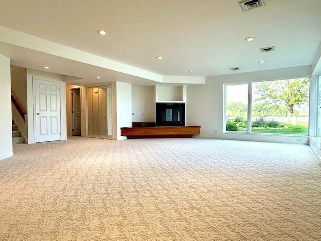 1976 Bay St, Worthington, MN 56187 - unfurnished living room featuring carpet flooring, recessed lighting, stairs, and baseboards