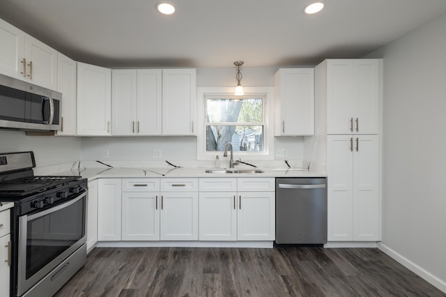kitchen featuring stainless steel appliances, a sink, dark wood-style flooring, white cabinets, and recessed lighting