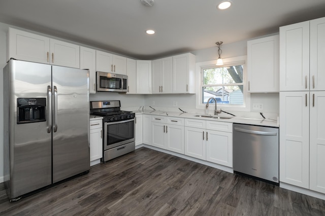 kitchen with appliances with stainless steel finishes, a sink, white cabinets, dark wood-style floors, and recessed lighting