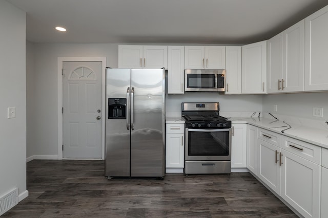 kitchen with appliances with stainless steel finishes, recessed lighting, white cabinetry, baseboards, and light stone counters