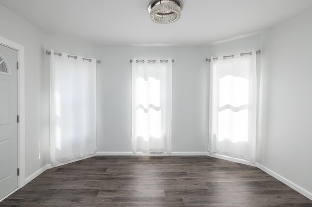 unfurnished room featuring dark wood-type flooring and baseboards