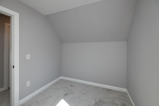 additional living space with carpet flooring, lofted ceiling, and baseboards
