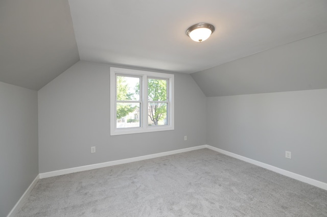 additional living space with carpet flooring, lofted ceiling, and baseboards