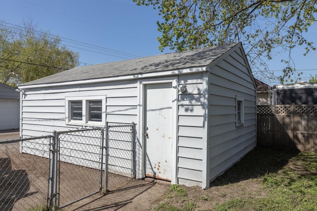 view of outbuilding with fence, a gate, and an outdoor structure