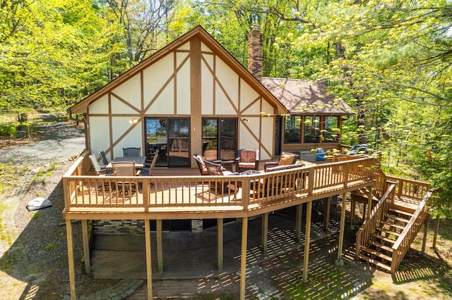 27166 Hersant Rd, Meenon Twp, WI 54893 - rear view of house featuring a deck, a chimney, stucco siding, and a shingled roof