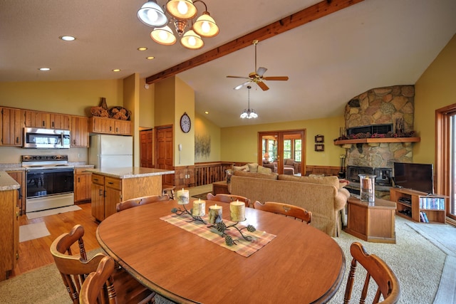 27166 Hersant Rd, Meenon Twp, WI 54893 - dining space with wainscoting, beamed ceiling, a fireplace, ceiling fan, and high vaulted ceiling