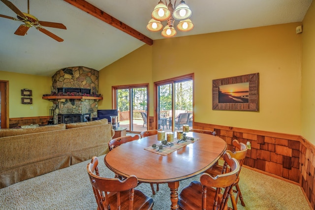 27166 Hersant Rd, Meenon Twp, WI 54893 - dining space with a stone fireplace, carpet floors, ceiling fan, a chandelier, and a wainscoted wall